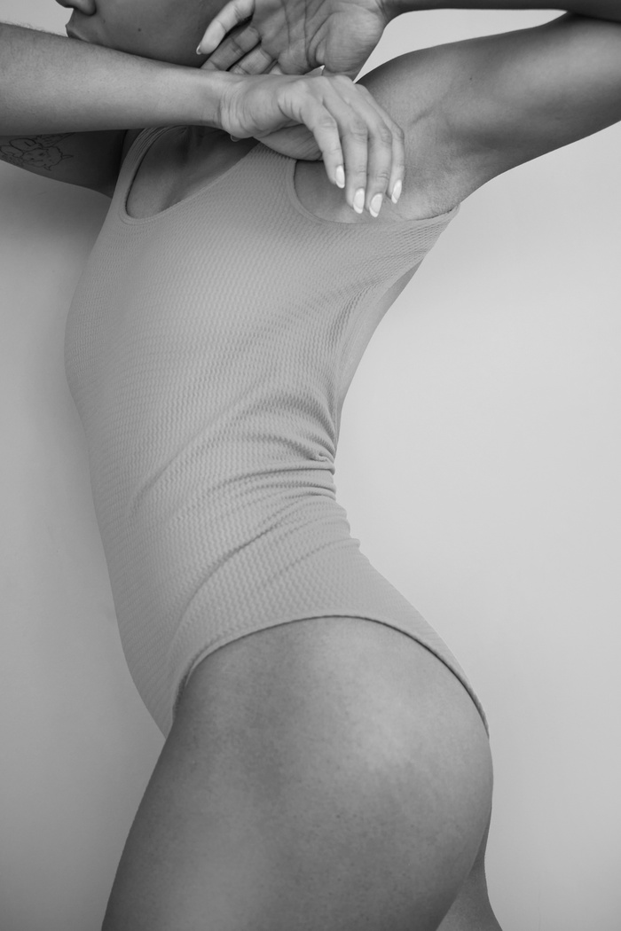 A Grayscale Photo of a Woman Wearing a Bodysuit